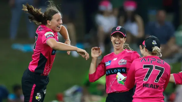 Caoimhe Bray celebrates a wicket with Sydney Sixers team-mates including Alyssa Healy