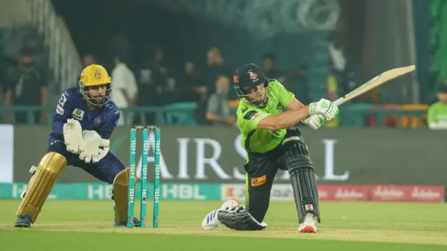 A Lahore Qalanders batter attempts a shot with Quetta Gladiators wicketkeeper Kusal Mendis behind the stumps.