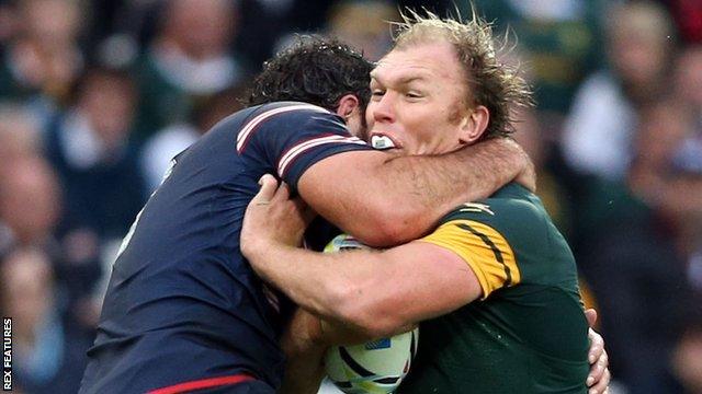 Schalk Burger is tackled by a United States player