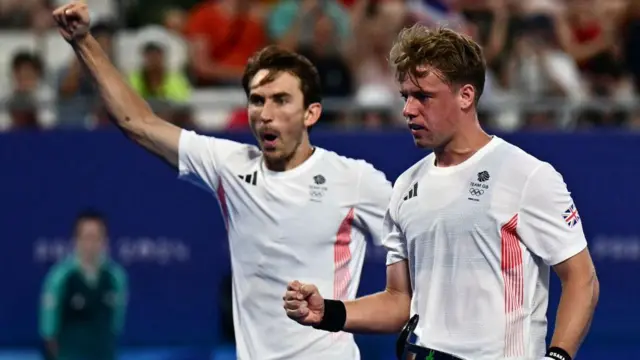 Gareth Furlong celebrates with teammates after scoring their second goal in the men's pool A field hockey match between Britain and Germany