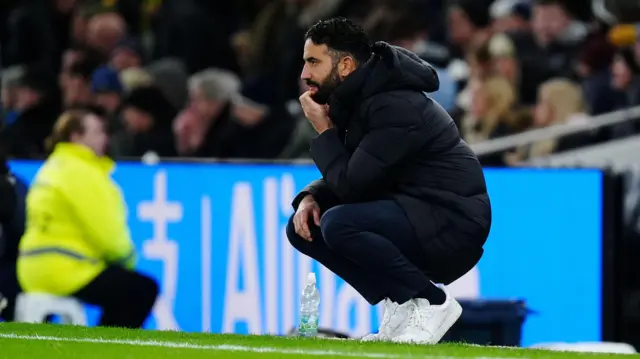 Ruben Amorim crouches down on the touchline