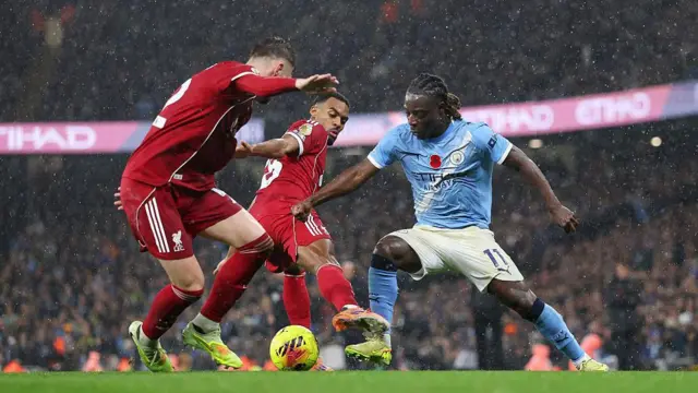 Jeremy Doku of Manchester City battles for possession with Ryan Gravenberch and Conor Bradley