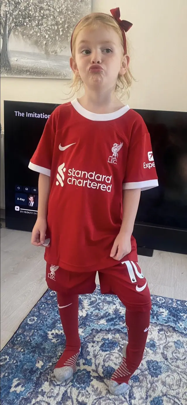 A picture of a six-year-old girl in a full Liverpool strip
