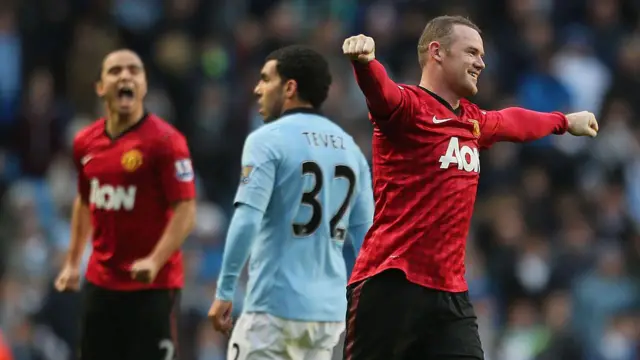 Rooney celebrates with Tevez in the background