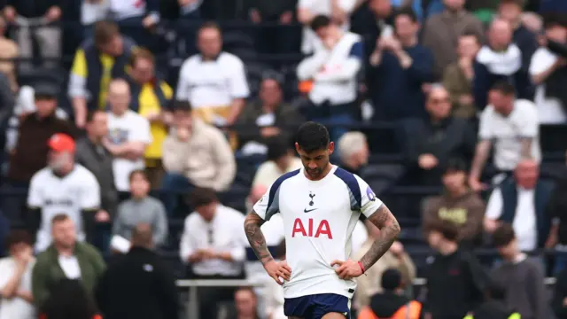 Cristian Romero looks down dejectedly in front of Tottenham fans