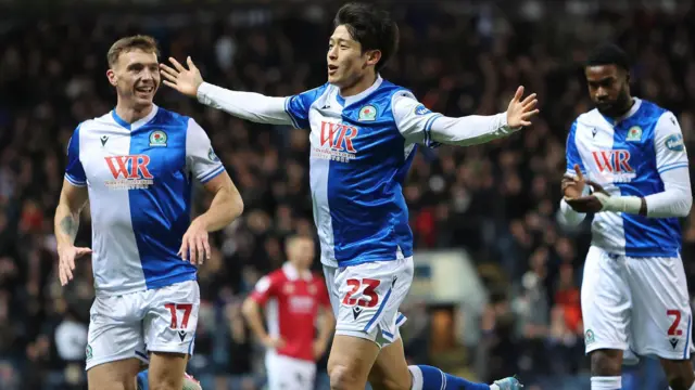 Yuki Ohashi celebrates scoring for Blackburn in their 2-1 defeat to Bristol City with his arms outstretched and the number 23 visible on his shorts he is closely followed by Hayden Carter on the left and Ryan Alebiosu on the right. Alebiosu is clapping