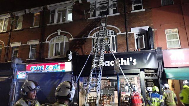 A picture from the scene of the fire that shows a ladder leaning against a property and at an open window. 