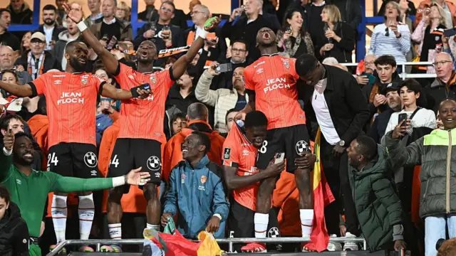 Lorient players and fans celebrate winning promotion in April 