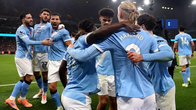 Manchester City players celebrate scoring against Liverpool together