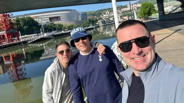 Three Tottenham fans pose for a selfie in front of the San Mames Stadium