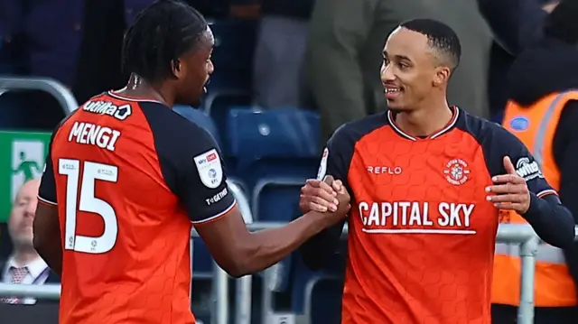 Corey Bramall shakes hands with team-mate Teden Mengi following his goal against Port Vale