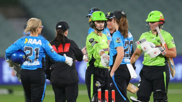 Phoebe Litchfield of the Sydney Thunder and Darcie Brown of the Adelaide Strikers shake hands as the match is abandoned due to rain during the WBBL match between Adelaide Strikers and Sydney Thunder