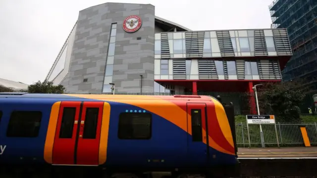 Train departs from outside Brentford's stadium