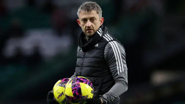 Gavin Strachan holds two yellow footballs as he looks on during a pre-game routine for Celtic