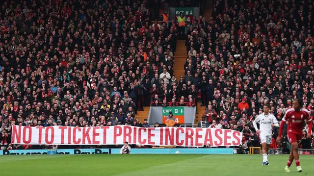 Fans of Liverpool display a banner in protest to the raising price.