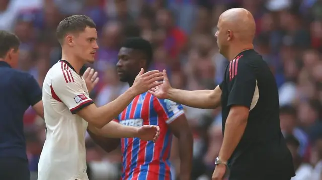 Florian Wirtz and Arne Slot high five one another after defeat to Crystal Palace
