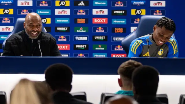 Lucas Radebe and Largie Ramazani speak in front of a branded backdrop during a workshop at Elland Road