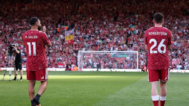 Mohamed Salah and Andrew Robertson of Liverpool acknowledges the fans in the Kop 