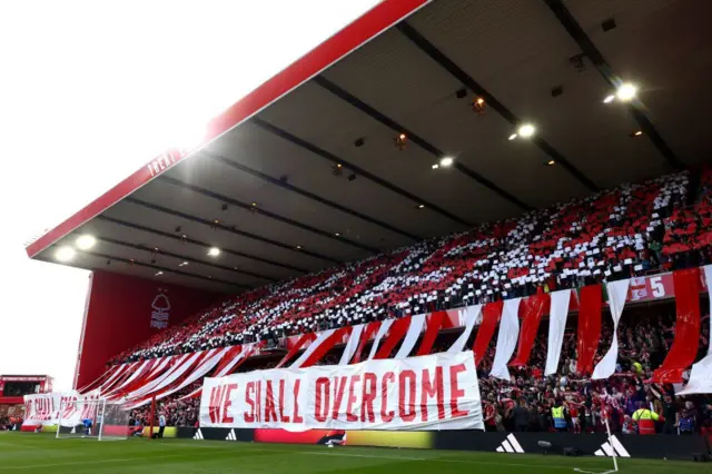 Nottingham Forest fans displaying a banner which reads 'We shall overcome'