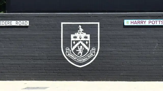 The Burnley badge painted on a wall outside Turf Moor