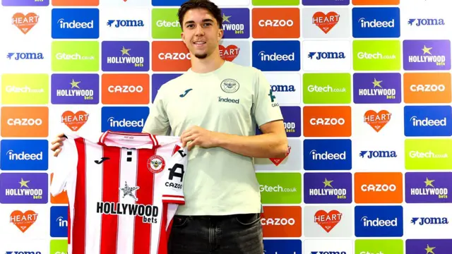 Jannik Schuster holds a Brentford shirt