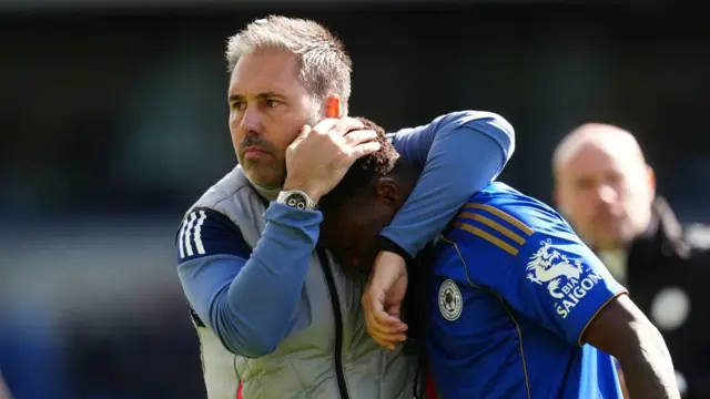 Marti Cifuentes brings Abdul Fatawu to his chest with his left arm wrapped around the back of his neck and his right hand on the top of Fatawu's head.