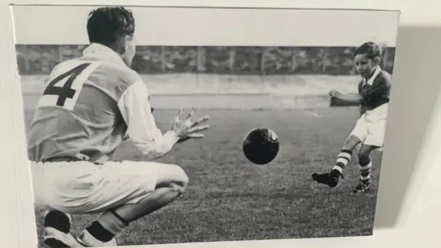 An old black and white photograph of a father and son playing football