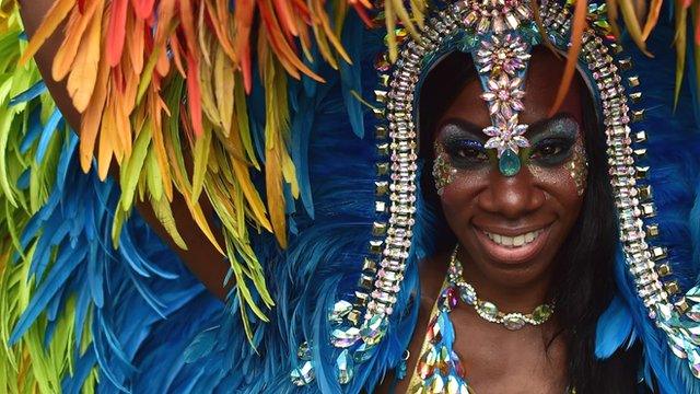 A performer poses for a photograph on the second day of the Notting Hill Carnival