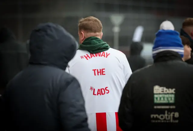 A Sunderland fan with Haway The Lads on the back of his shirt