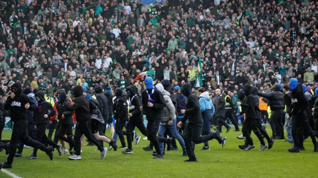 Fans invading the pitch at Ibrox following Celtic's win on penalties