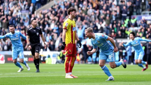 Watford's Rocco Vata looking into the distance as Coventry City players celebrate around him. 