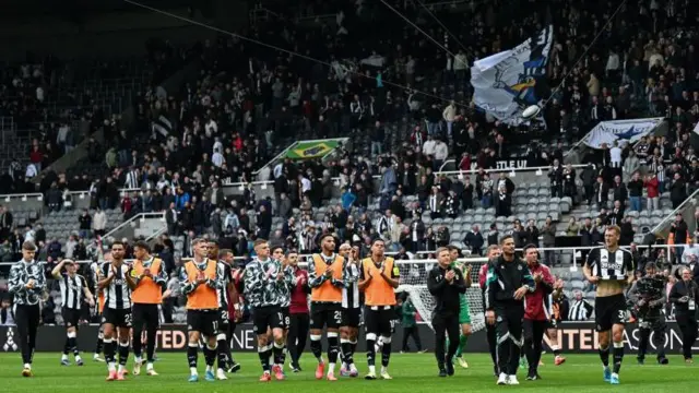 Newcastle players applaud fans after match