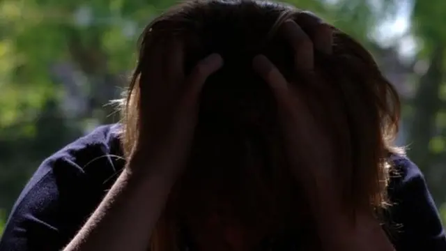 Woman holding her head in her hands