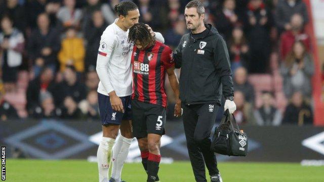 Nathan Ake being consoled by Virgil van Dijk as he leaves the field