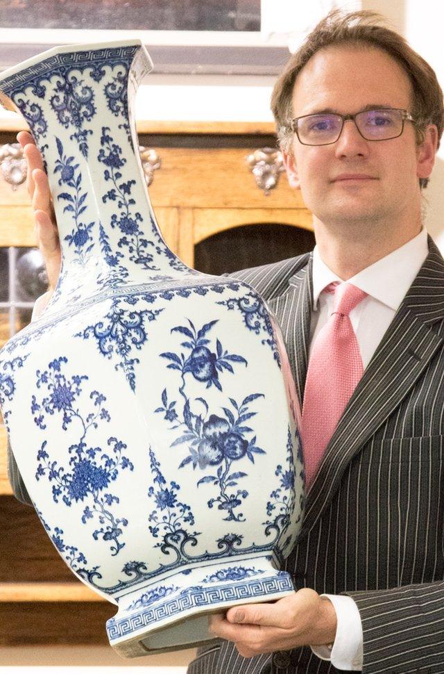 Large blue and white Chinese vase held by auctioneer