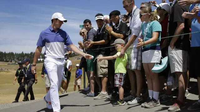 Rory McIlroy hands a young fan a ball