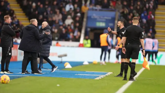 Referee Andy Madley shows a yellow card to Leicester City Manager Steve Cooper