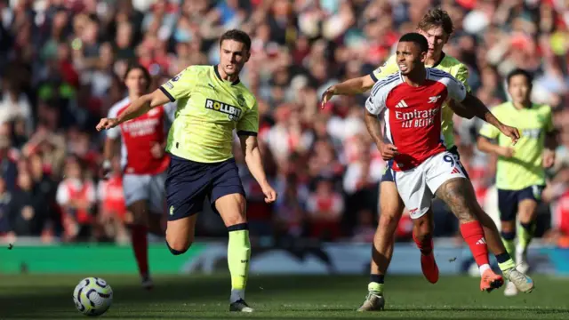 Taylor Harwood-Bellis of Southampton and Gabriel Jesus of Arsenal battle for the ball