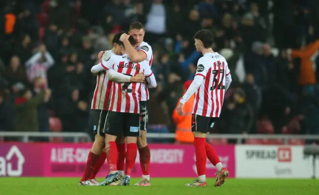 Sunderland's Luke O'Nien, Daniel Ballard, Trai Hume, and Niall Huggins are celebrating at full time during the Championship match between Sunderland and Leeds United at the Stadium of Light in Sunderland