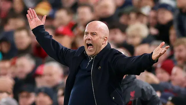 Arne Slot stands arms open in protest during Liverpool 1-2 Manchester City