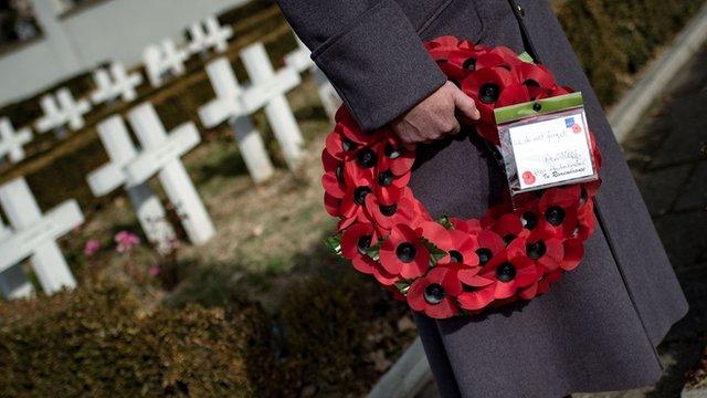 A British Royal officer holds a wreath of poppies at the French soldiers' cemetery in Belgrade