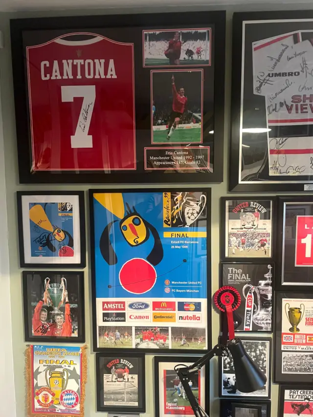 A wall full of photo frames showcasing Manchester United memorabilia