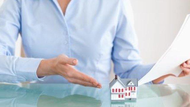 Woman pointing to a model house