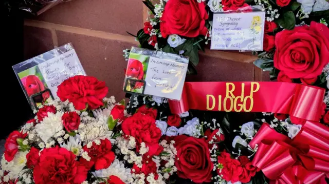 Red flowers laid outside Anfield with a ribbon reading 'RIP Diogo'