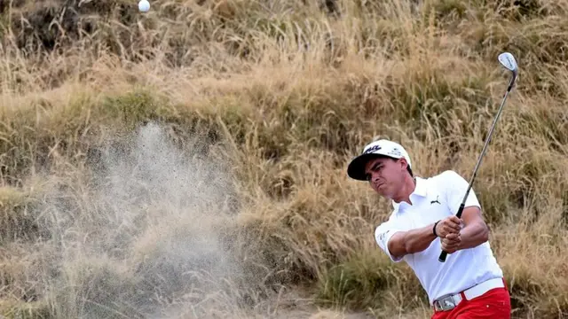 Rickie Fowler plays a shot from the bunker