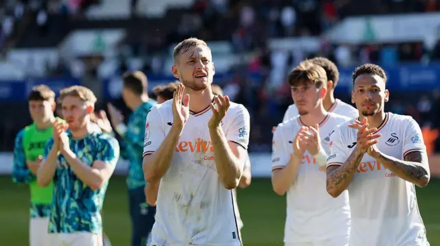 Swansea players celebrate after beating Derby