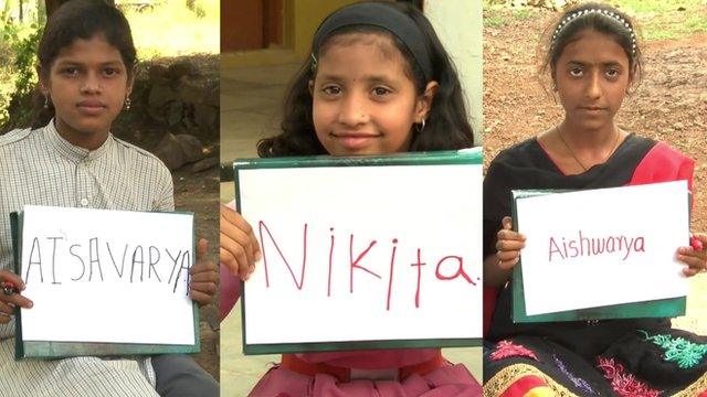 Three girls holding up boards with their new names