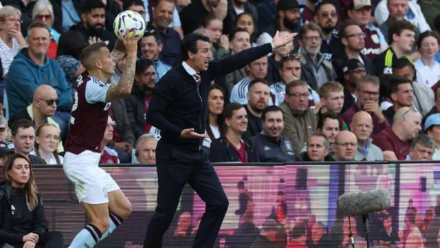 Aston Villa's Spanish head coach Unai Emery gestures on the touchline as Aston Villa's French defender #12 Lucas Digne prepares to take a throw-in