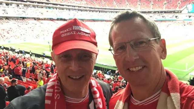 An image of two men with Wembley in the background