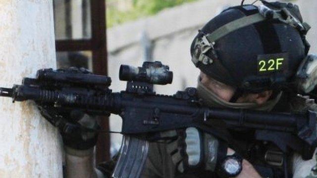 A NATO soldier aims his weapon during a gun battle in Kabul, Afghanistan